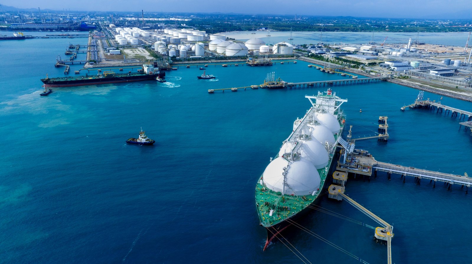 LNG (Liquified Natural Gas) tanker anchored in Gas terminal gas tanks for storage.